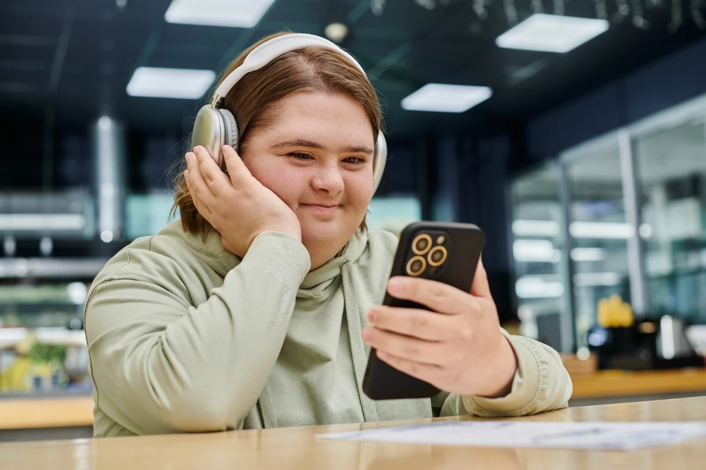 Disabled woman wearing heaphones, using mobile phone and smiling
